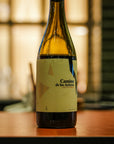 Wine by alvar de dios, 'Camino de los Arrieros' on a wooden surface with a blurred background.